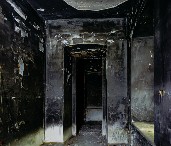 a fire damaged hallway with walls covered in soot