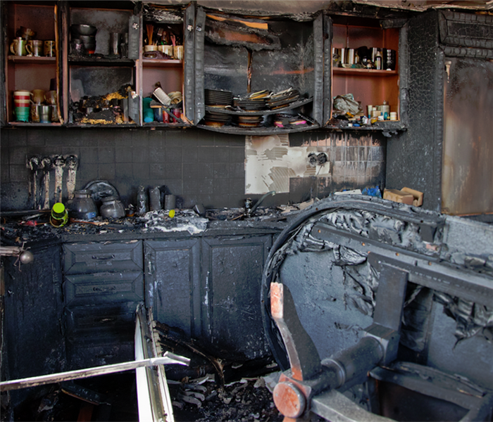 a fire damaged kitchen with soot covering the walls and counters